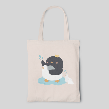 Beige colour designed tote bag with a cartoon penguin in duck floatie, and two ducks are following, front side