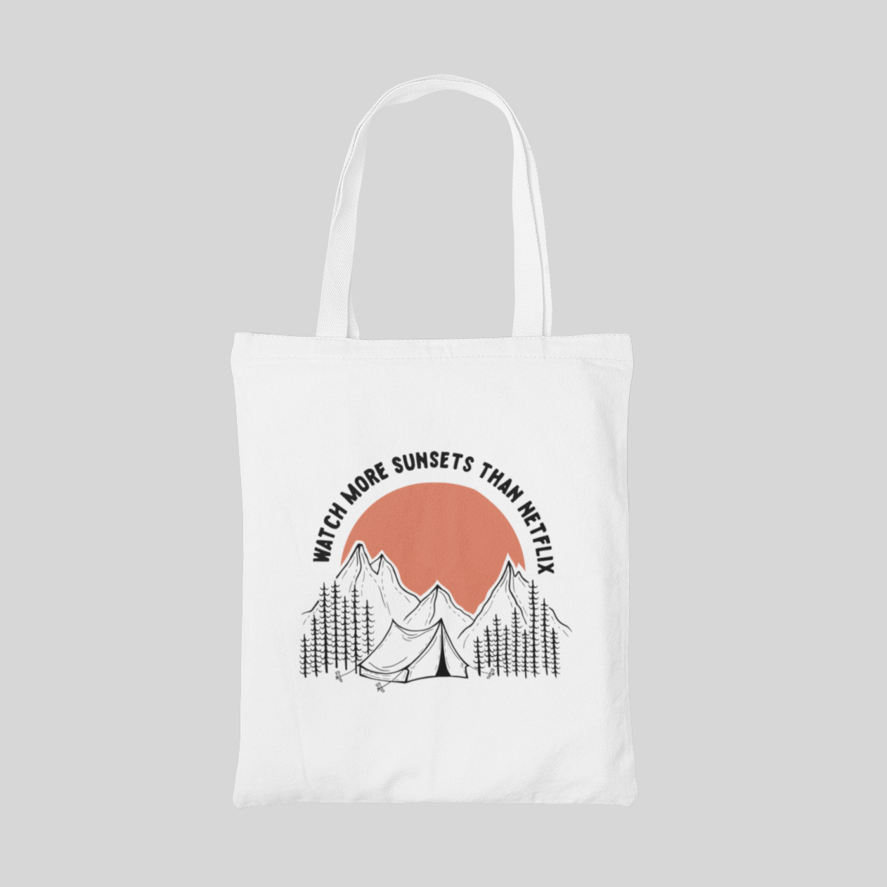 white minimalist designed tote bag with a tent in forest, a big orange sun behind the mountain, and "watch more sunsets than netflix" lettering quote, front side