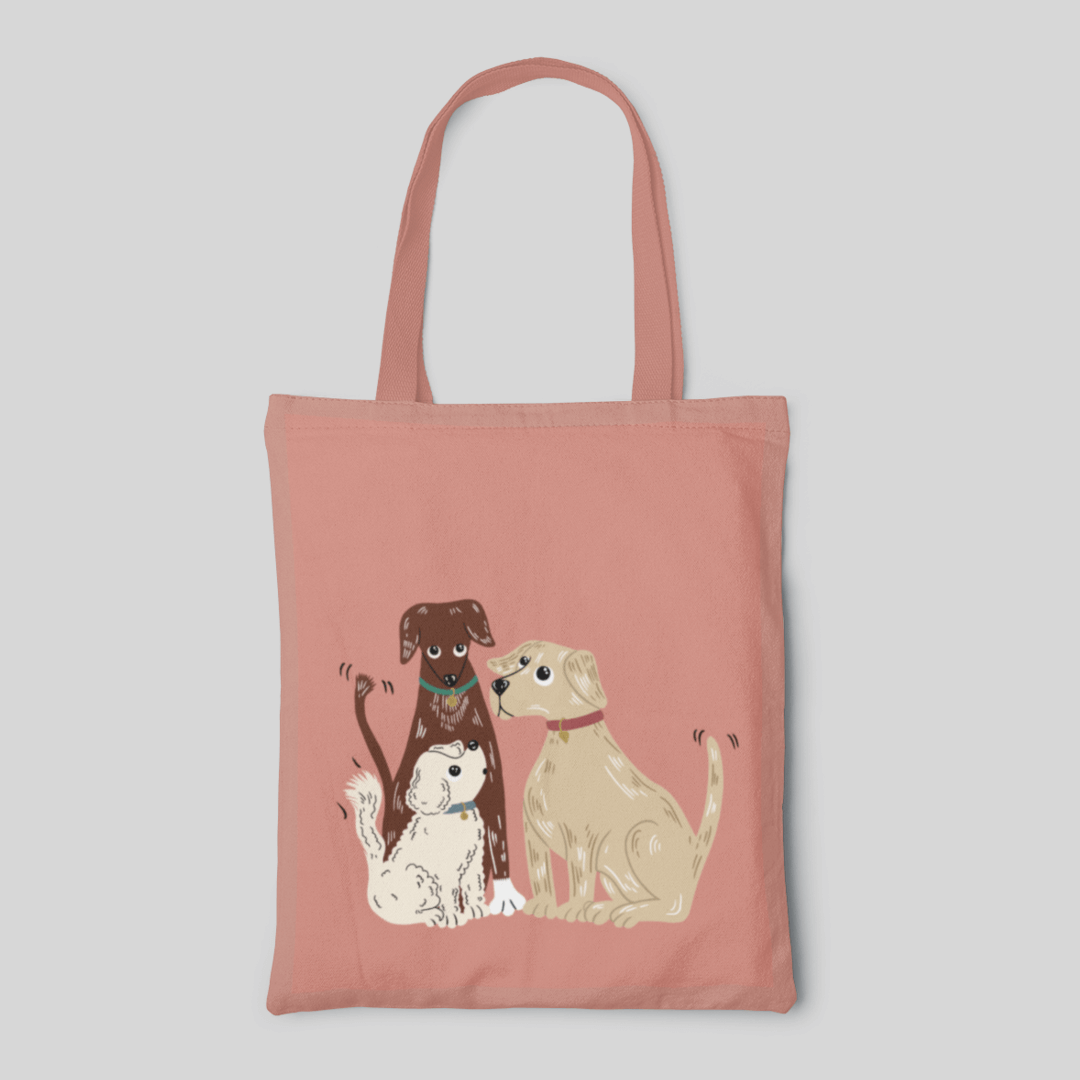 peach designed tote bag with three cute dogs in brown golden and white shaking their tails, front side