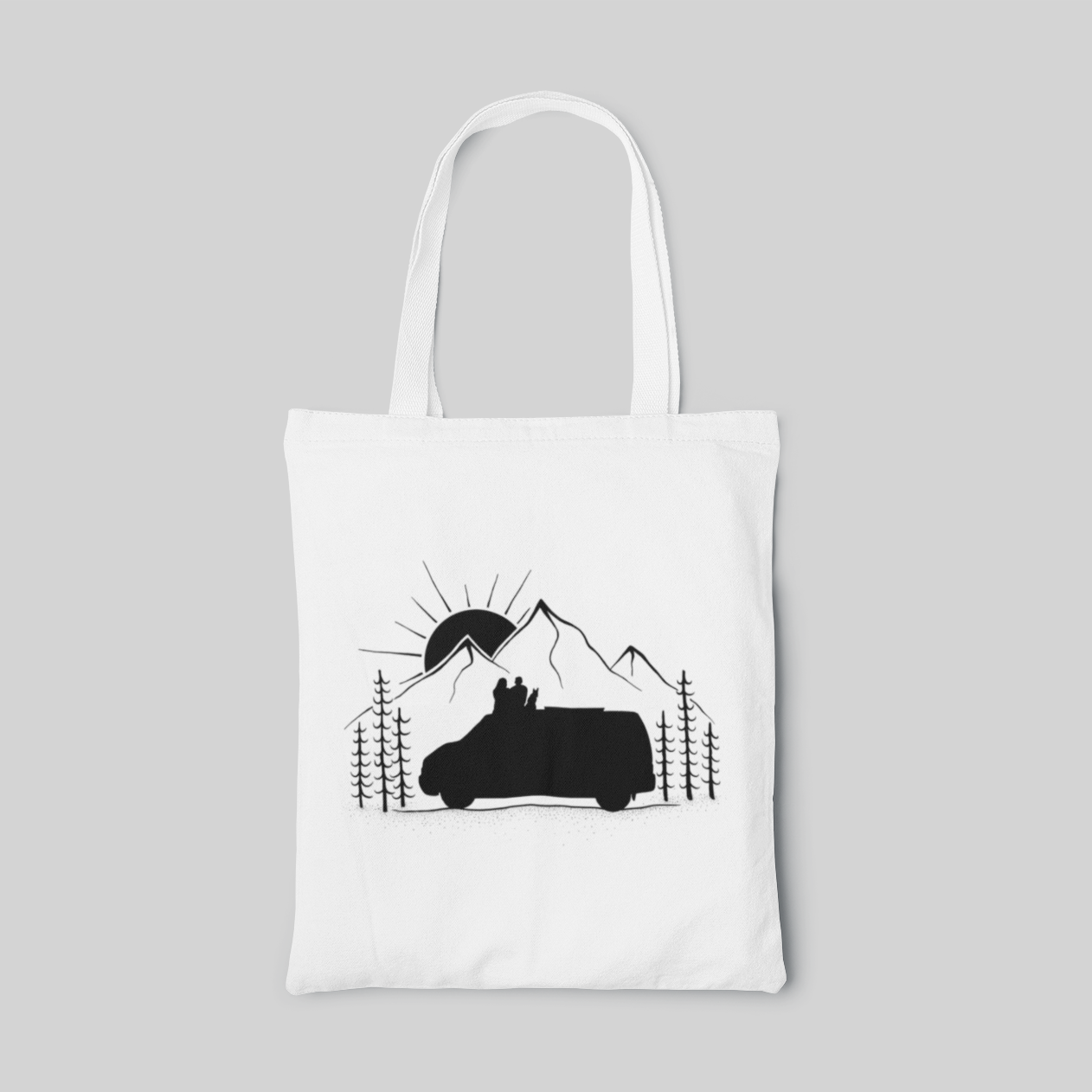 White minimalist designed tote bag with monochrome illustration of car next to mountains, a couple and a dog sitting on the car and watching the sun rise or set behind the mountain, front side
