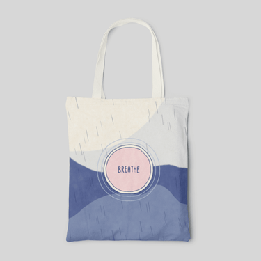 White and blue minimalist designed tote bag with 'breathe' lettering and circle shapes in the middle of the bag, front side