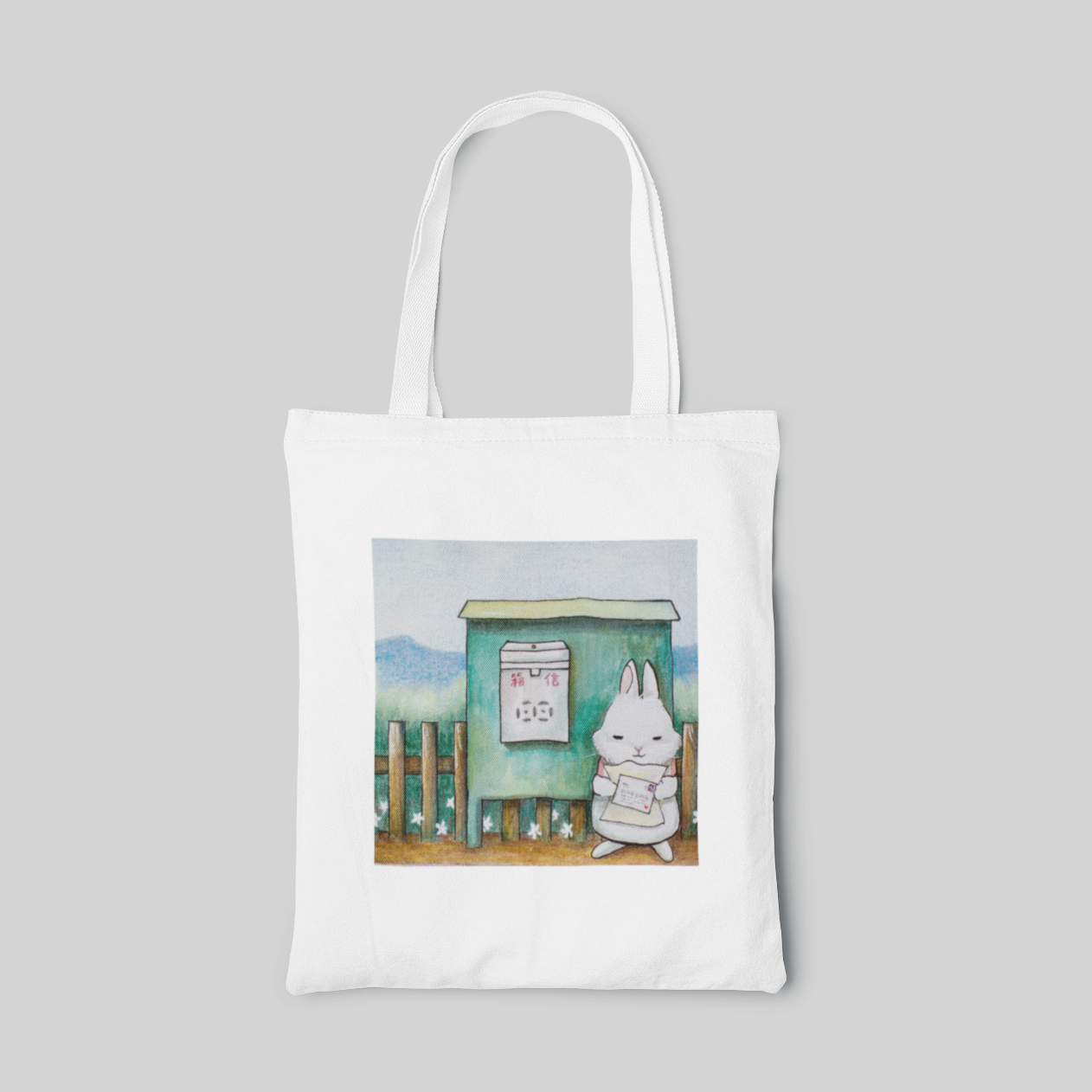 a lowbrow designed tote bag with a cartoon white rabbit reading letters next to the mail box, front side