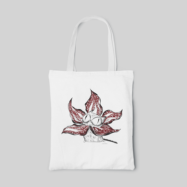 White lowbrow designed tote bag with sketches of a white cat in the middle of red flower, front side
