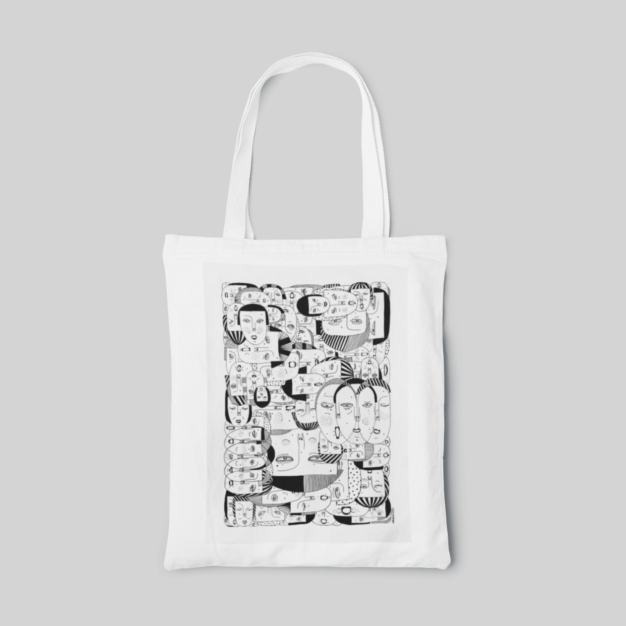 White tote bag with monochrome caricature face illustrations 