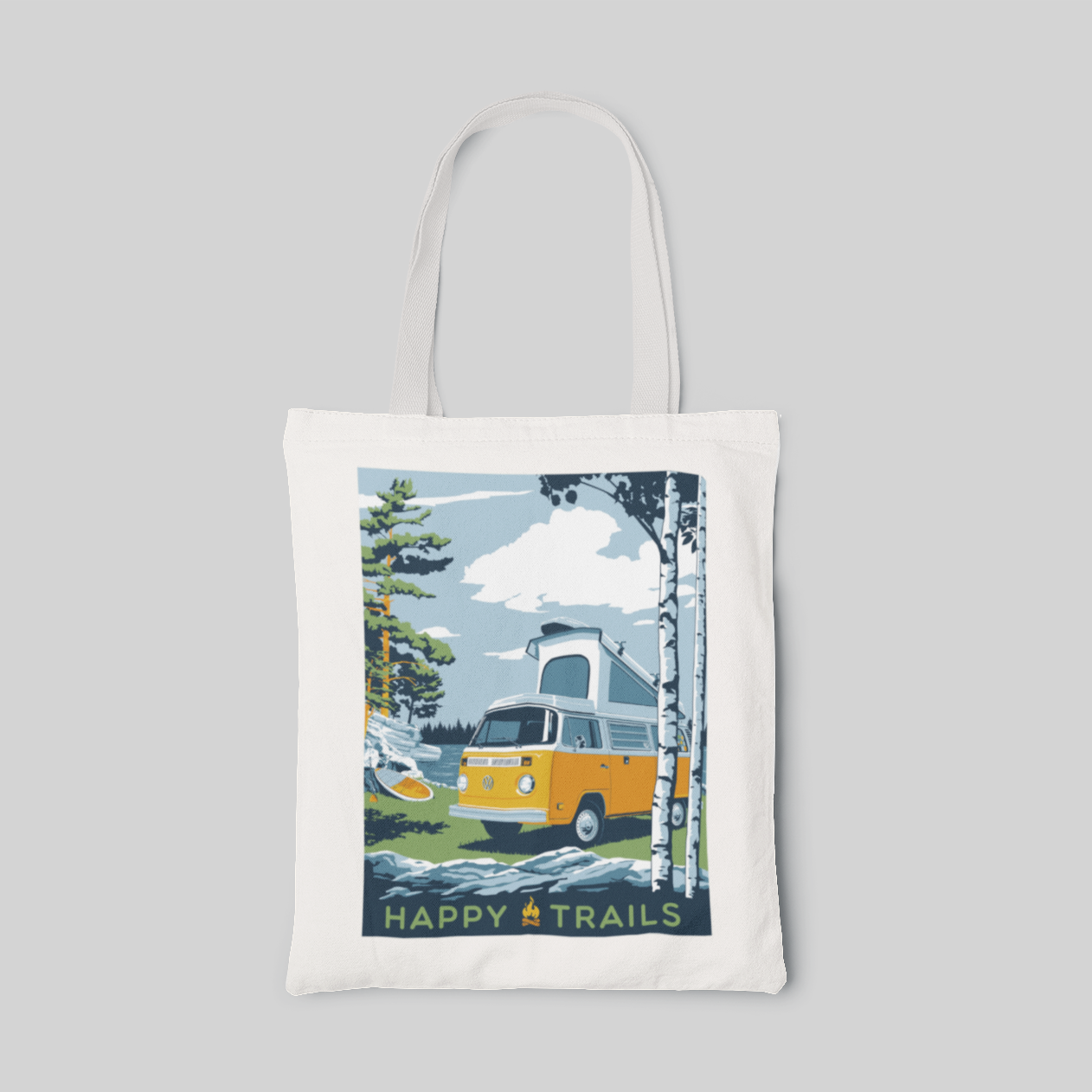 White nature designed tote bag with forest illustrations, yellow camping bus and "happy trails" lettering at the bottom, front side
