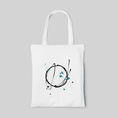 White minimalist designed tote bag with black line art in a circle and greenish blue paint splatters, front side