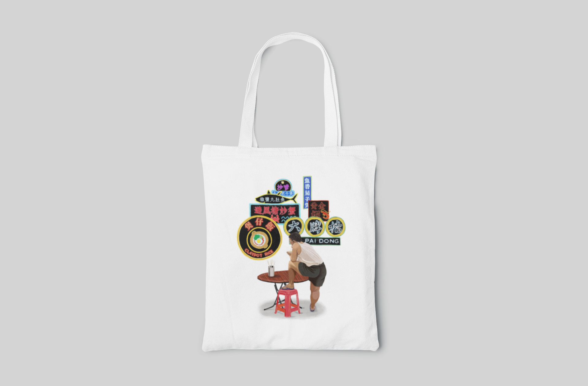 White urban designed tote bag with illustration of a guy sitting at red chair next to the table and many HK neon lights in the background, front side